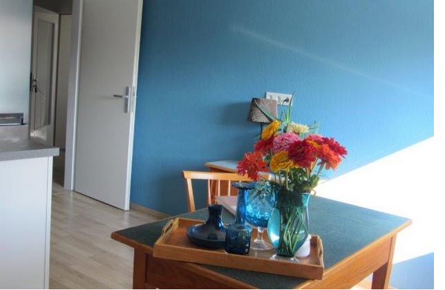 Essbereich mit blauer Wand und frischen Blumen