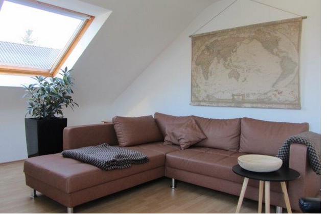 Wohnzimmer mit Couch, Weltkarte und Dachfenster