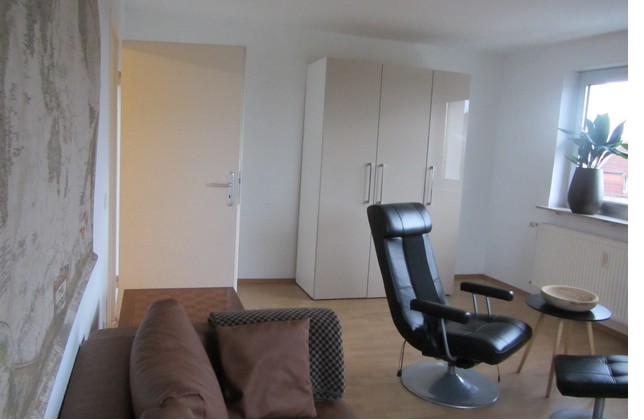 Wohnzimmer mit Funktionscouch und Fernsehsessel